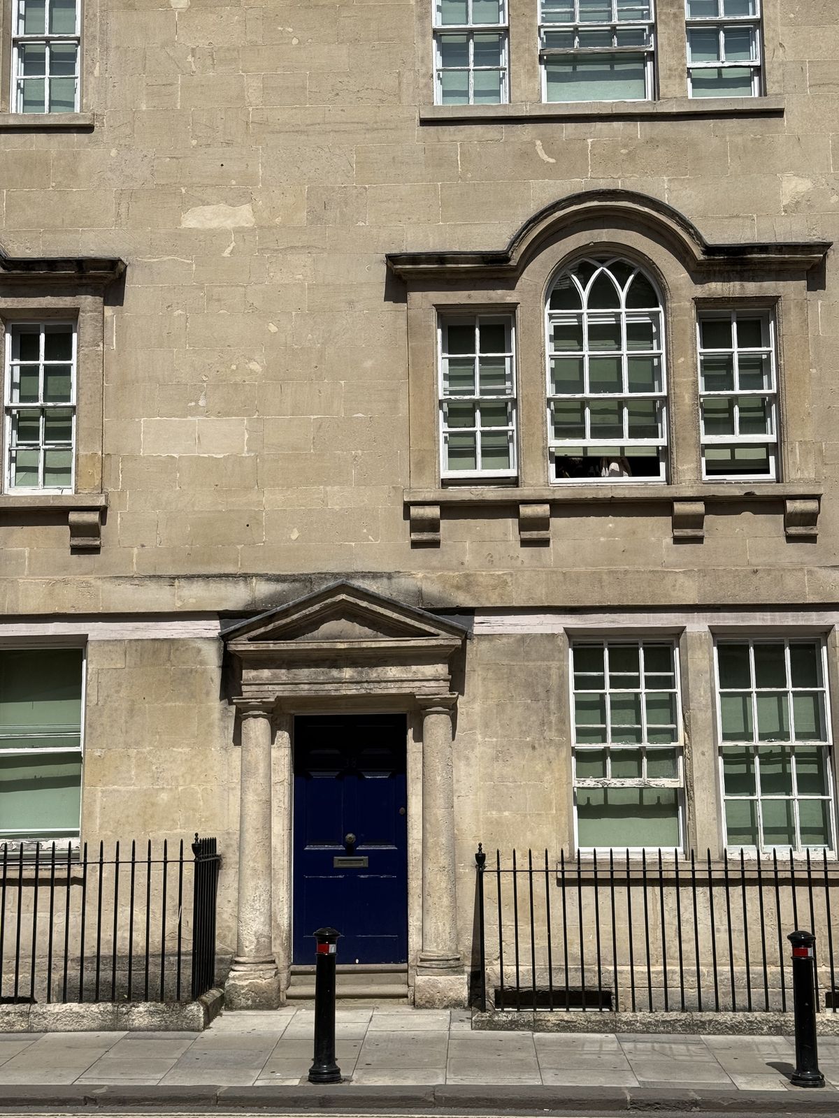 A Georgian townhouse in Bath with a blue front door and fanlight in honey-coloured stone